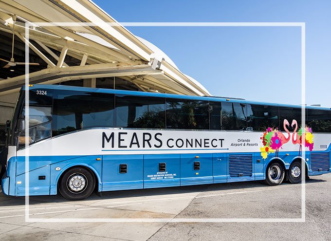 Blue and white Mears Connect Motorcoach with colorful Mears flamingo mascots, Fran and Frank, parked at Orlando International Airport